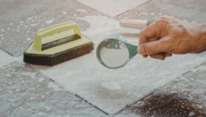personne qui nettoie du carrelage avec bicarbonate et éponge spéciale