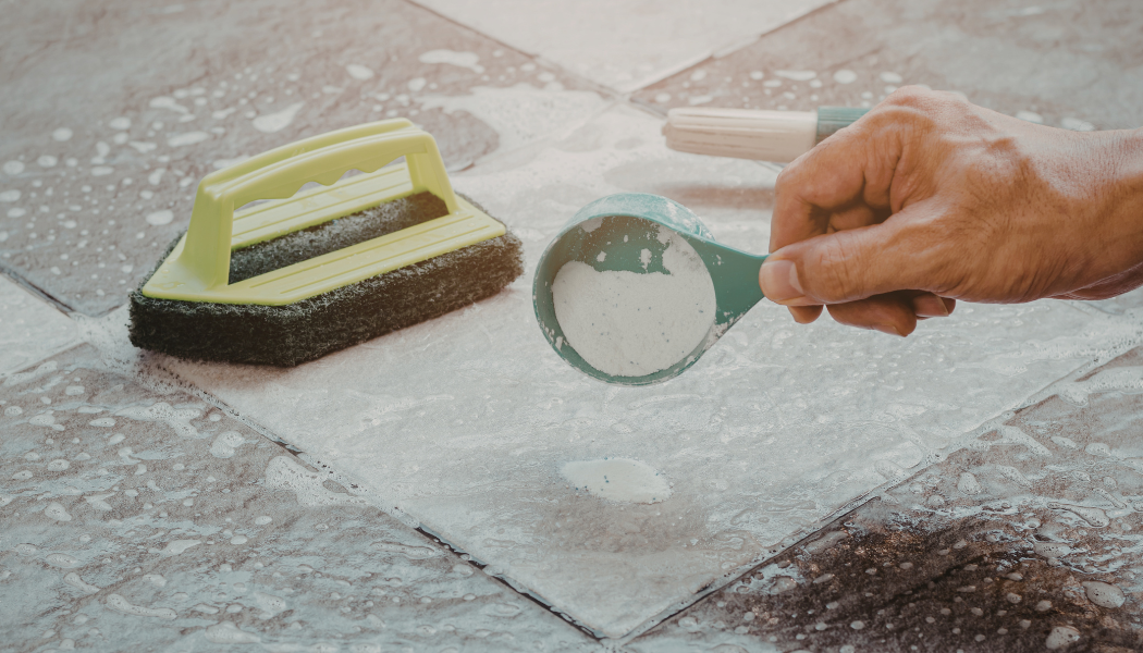 personne qui nettoie du carrelage avec bicarbonate et éponge spéciale