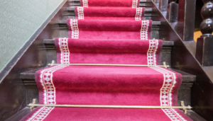 moquette rouge sur un escalier en bois