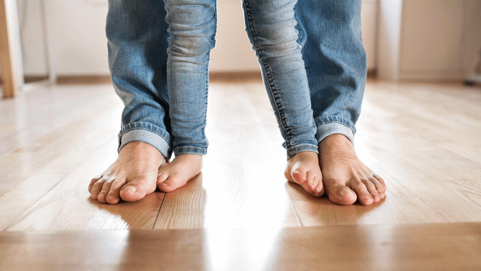 Pieds nus d'un adulte et d'un enfant sur du parquet rénové